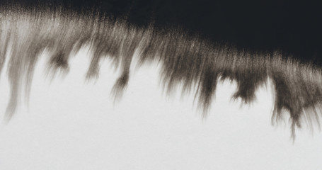 closeup black ink border spreading on wet paper top view