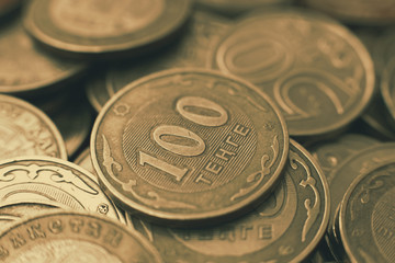 Many hundreds of tenge of coins, Kazakhstan money. Sepia tone of the photo.