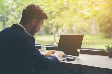 Young businessman working on laptop at office. Working people concept.