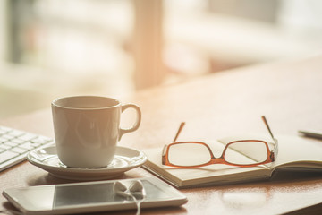 Business concept. Office supply on desk table with cup of coffee and analysis chart, smartphone, keyboard, notebook, pen,earphones on desk.