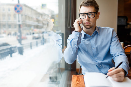 Young jobless man making appointment with employer on the phone