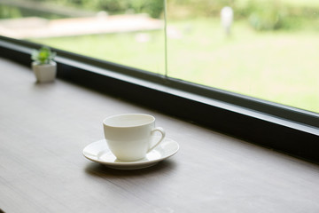 Close up of coffee up on the wooden table near a window in morning.