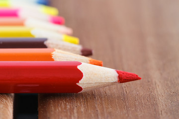 Obraz premium Set of colored pencils with a single sharp one symbolizing leadership concept