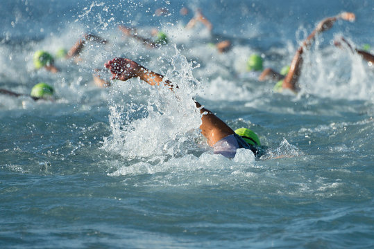 Group people in wetsuit swimming at triathlon