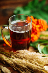 green circle in the scarf, the window with maple leaves and drops after rain in autumn / season when you need warm drinks