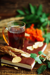 green circle in the scarf, the window with maple leaves and drops after rain in autumn / season when you need warm drinks