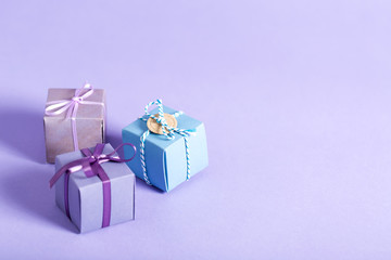 Little handmade present boxes on a purple background
