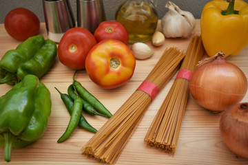 Raw organic spaghetti and fresh vegetables prepared for cooking pasta.