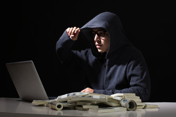 Hacker get a lot of Money that Hacking from online in the dark, Man with Hacker Concept.