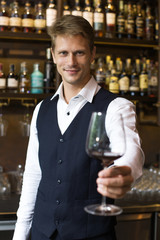 Handsome sommelier man smelling wine at restaurant, Man smelling Wine in wineglass, Man with Sommelier Concept.