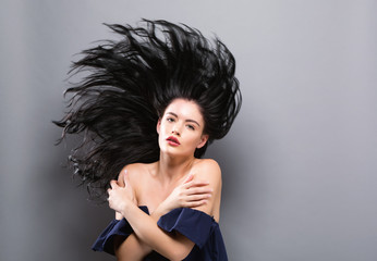 Young woman with floating hair on a solid background