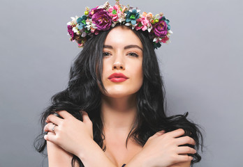 Fototapeta premium Beautiful young woman with a garland on a solid background