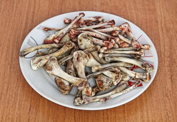 Heap of picked chicken bones on a plate.