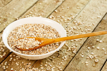 Uncooked oatmeal and wooden spoon