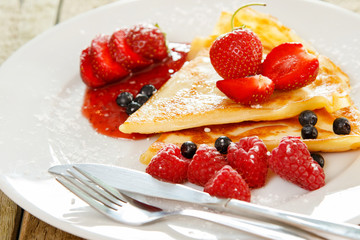 Pancakes with berries and sugar powder