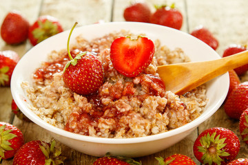 Cooked oatmeal, berries and strawberry jam
