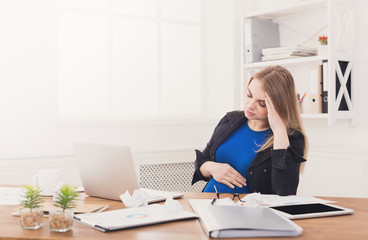 Tired pregnant businesswoman at office copy space