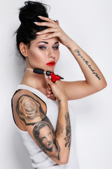 Young woman tattooist with a tattoo-machine in her hand - obrazy, fototapety, plakaty
