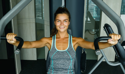 Woman using press machine in the gym