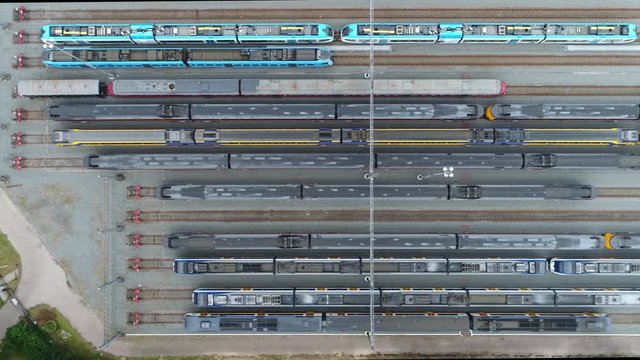 Aerial moving right above railway hub showing passenger trains on tracks next to each other top down view drone moving slowly showing railway tracks positioned horizontally above each other 4k quality