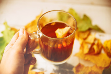 Cup of tea with autumn leaves. Top view.