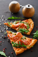 Pizza with prosciutto and rocket salad copy space