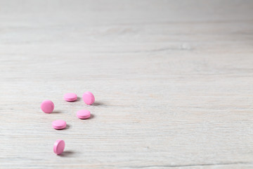 Heap of pink round pills on bright table
