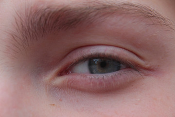 Green eye of a teenage boy.