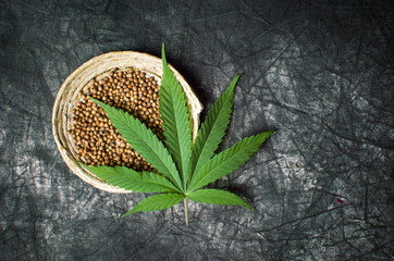 Cannabis seeds in bowl on dark textured background