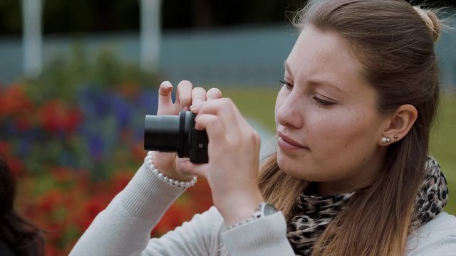 Young girl is taking a photo at a park