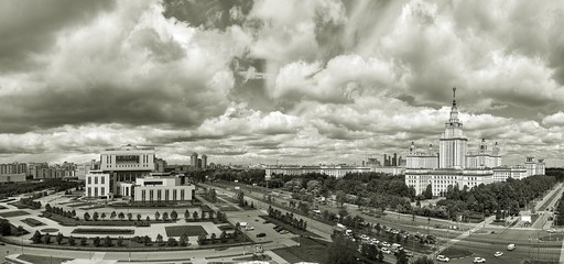 Black and white wide angle panoramic landscape view of dramatic clouds over the sunny summer campus of Lomonosov Moscow State University