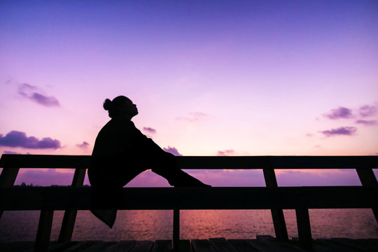 Silhouette Women Sit On The Branch And Think About Something In Her Lift With Butiful Twilight Sky