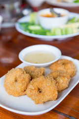 Deep-fried shrimp cakes, served on white dish and served with sweet plum sauce, Thai style appetizers, delicious Thai food.