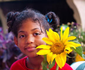 happy little girl with a sunflower in the hands