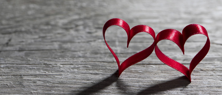 Two ribbon hearts on wood