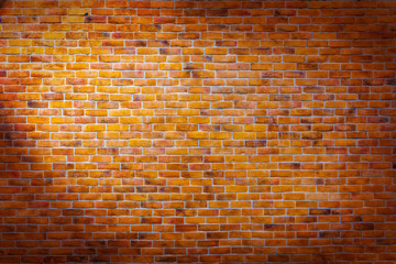 Fototapeta na wymiar Vintage brick wall background with left spotlight on the wall