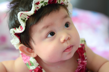 Close up of adorable healthy baby asian girl drooling.