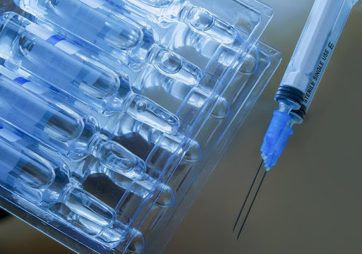 Ampoules packing and syringe. Mirror surface.