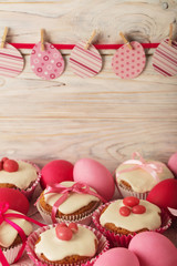 Easter cupcakes with white icing decorated with pink candy and ribbons.