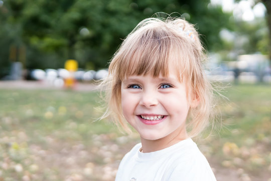 Close-up portrait of a beautiful little girl laughing happily