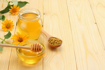 honey dipper and honey on light wooden table