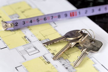 Keys with measure on architectural drawings of the modern apartment. Financing and planning a new house.