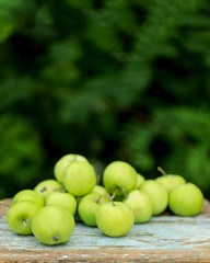 Homemade rustic green apples on an old stool.