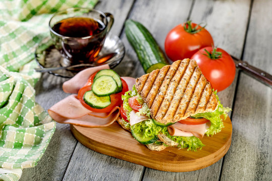 Sandwich with ham, cucumber, tomato and lettuce.