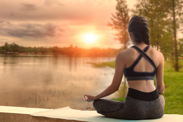 Woman do yoga outdoor. Woman exercising vital and meditation for fitness lifestyle club at the nature background with copy space.