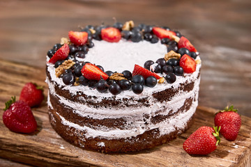 a cut of cake with whipped cream and strawberry fruits on wood table