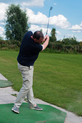 Golfspieler beim Abschlag auf einem Golfplatz