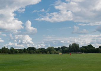 Driving range auf einem Golfplatzplatz mit vielen Golfbällen