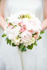 Bride in a dress with a bouquet of wedding flowers