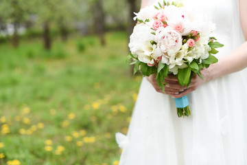 Bride in a dress with a bouquet of wedding flowers